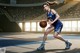 A woman in a blue uniform holding a basketball on a court.