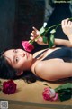 A woman laying on a table with a rose in her hand.