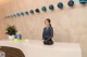 A woman standing at the front desk of a hotel.