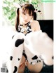 A woman in a cow costume sitting on a couch.