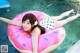 A woman laying on an inflatable donut floating in a pool.