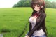 A girl in a school uniform standing in a field.