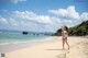 A woman in a bikini standing on a beach.