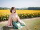 A woman sitting in a field of sunflowers.